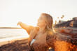© Daniel - Portrait of one young woman at the beach with openened arms enjoying free time and freedom outdoors. Having fun relaxing and living happy moments..