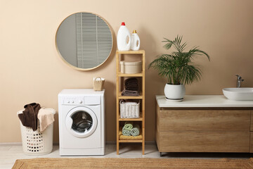 Poster - Stylish laundry room interior with washing machine, vessel sink, houseplant and basket