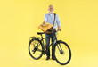 © New Africa - Postman with bicycle delivering letters on yellow background