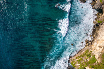 Wall Mural - Top down of waves crashing in ocean near Uluwatu temple in Bali, Indonesia