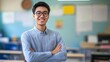 © The Little Hut - In school asian male teacher stands smiling with arms crossed in the classroom : Generative AI