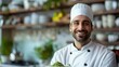 © Fudi - Smiling Chef Holding a Plate of Green Powder in a Kitchen