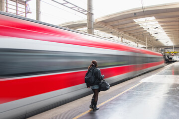 Wall Mural - Red high speed train runs on rail tracks - The train is going too fast as a result the air pressure is causing too much heat at the front