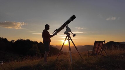 Wall Mural - Amateur astronomer looking at the evening skies, observing planets, stars, Moon and other celestial objects with a telescope just before sun down.	
