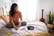 © Daniel - Relaxed Asian female teen college student sitting on bed writing on diary in cozy bedroom. Copy space.