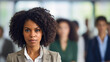 © wetzkaz - Satisfied and proud African-American woman with curly hair in a beige business suit, standing confidently in front of work colleagues or business partners