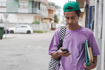 Wall Mural - teenage student using smartphone on the street