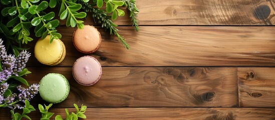 Poster - Macaroon displayed with plants on a wooden floor with copy space image