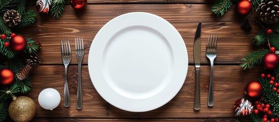 Poster - Festive table setting for Christmas and New Year holiday concept on a wooden background with an empty white plate cutlery and decorations Copy space image