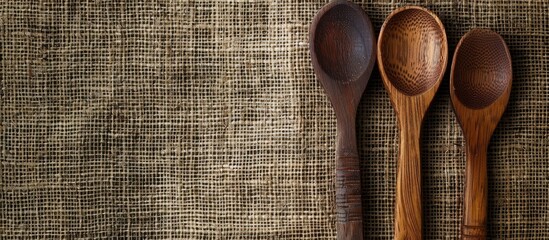 Poster - View from above of a wooden spoon and fork on a burlap surface with copy space image