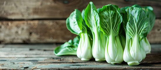 Wall Mural - Copy space image of green bok choy or pac choi Chinese cabbage on a wooden surface seen from the side in a close up shot