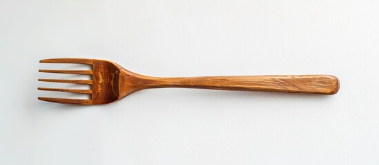 Poster - One wooden fork isolated on a white background is a kitchen utensil for food enthusiasts Ideal as a background wallpaper or copy space image