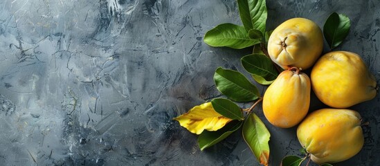 Poster - Fresh organic quinces with leaves on a grey table top view perfect for adding text in the copy space image