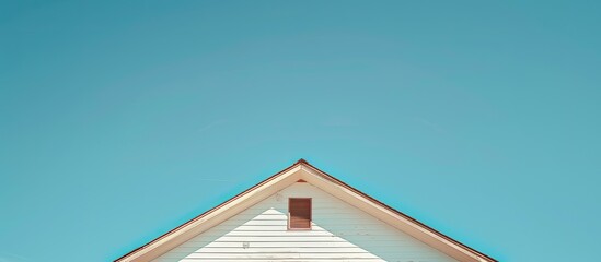 Wall Mural - A triangular house roof against a clear blue sky with copy space image