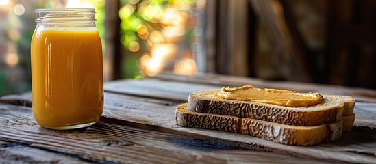 Poster - Homemade peanut butter on toast fresh orange juice on a wooden table in side view with copy space image for breakfast or brunch