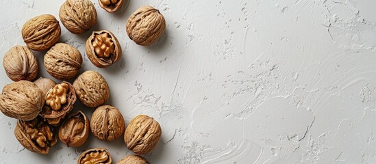 Poster - Top down view of walnuts in shells on a white stone surface ideal for adding text to the image. Creative banner. Copyspace image