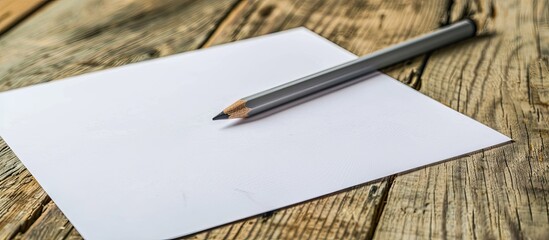 Fototapete - Wooden background with a white paper and a gray pencil with copy space image
