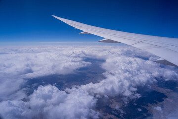 Wall Mural - view from an airplane on a blue sky and white clouds