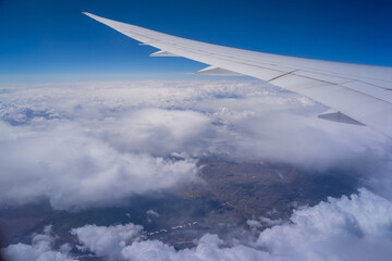 Wall Mural - view from an airplane on a blue sky and white clouds