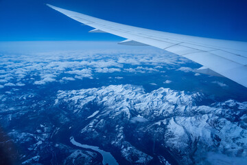 Wall Mural - view from an airplane on a blue sky and white clouds