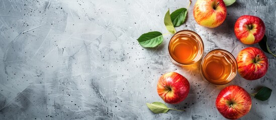 Healthy eating and lifestyle concept with a copy space image of apple cider or fermented fruit drink and organic apples on a concrete background symbolizing the harvest