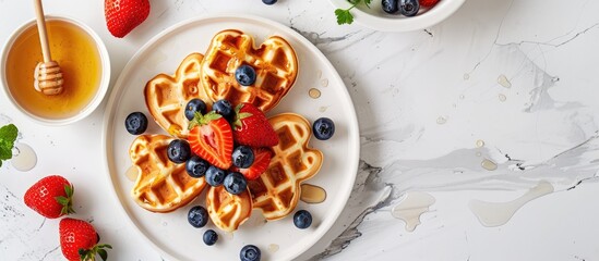 Poster - Heart shaped homemade Belgian waffles topped with fresh strawberries blueberries and honey displayed on a white kitchen table with space for images. Creative banner. Copyspace image