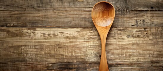 Poster - Wooden spoon displayed on a textured wood backdrop with copy space image