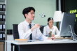 © NINENII - Asian employee working at office with laptop and documents on desk, People Work in Business Office.