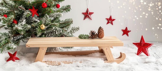 Wall Mural - A simple and bright Christmas composition featuring a decorative fir tree wooden sledge snow and shimmering red stars in a copy space image