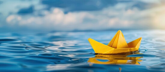 Poster - A yellow origami boat floats on the blue lake water heading towards big dreams symbolizing summer travel and freedom against a sky background with a copy space image