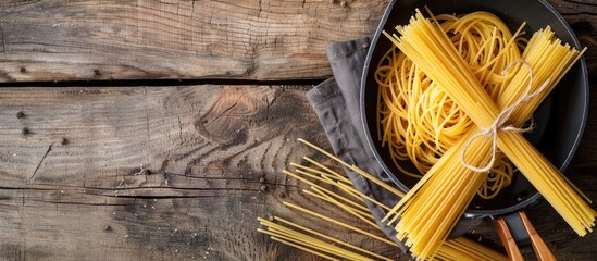 Poster - Uncooked pasta in a pan on a rustic wooden backdrop showcasing a copy space image