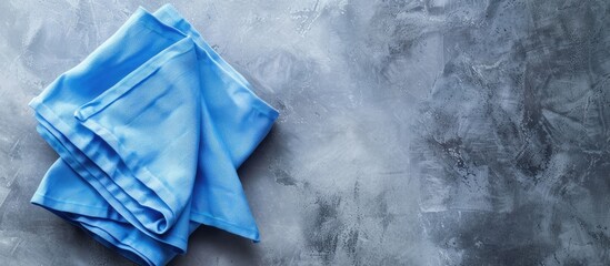 Poster - A folded blue kitchen napkin isolated on a table background ideal for mockups with copy space image Set in a minimalist flat lay style