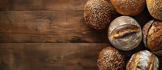 Poster - Overhead shot of diverse homemade multigrain bread loaves on a wooden surface with a blank space for an image. Creative banner. Copyspace image