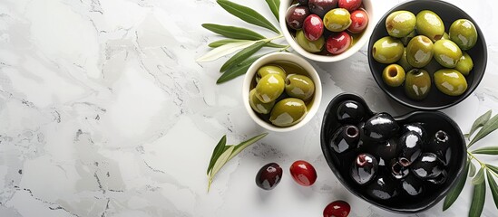 Poster - A variety of green red and black olives displayed on a bright marble surface with bowls of olives and olive leaves suitable for vegans accompanied by a blank area for text beside the image