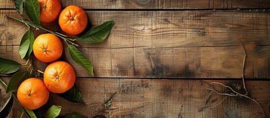 Poster - Weathered wooden surface featuring oranges with leaves providing copy space image
