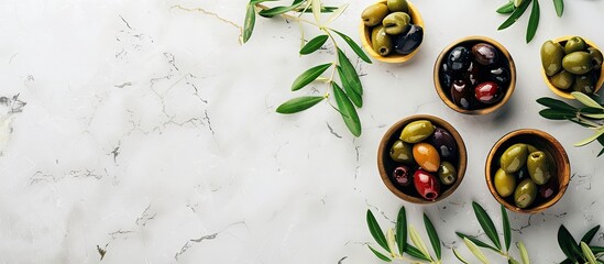 Poster - A variety of green red and black olives displayed on a bright marble surface with bowls of olives and olive leaves suitable for vegans accompanied by a blank area for text beside the image