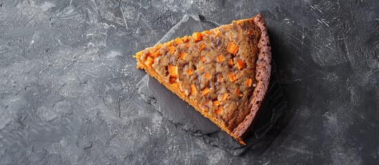 Poster - Top view of a vegan raw carrot cake on a gray stone surface with copy space and selective focus showcasing a slice of healthy homemade cake
