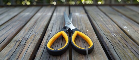 Sticker - A set of pliers with contrasting black and yellow handles resting on a wooden floor deck in a copy space image