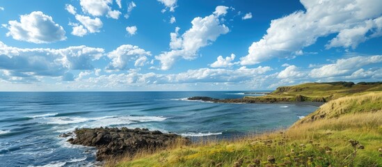 Poster - Scenic coastal view with clear blue skies and fluffy clouds on a sunny day featuring a wide copy space image