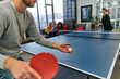 © .shock - Business colleagues take a break from work to enjoy a game of table tennis, fostering teamwork and camaraderie in the workplace