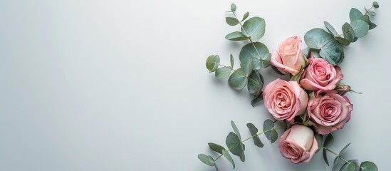 Wall Mural - Copy space image of a floral wreath consisting of pink roses and eucalyptus leaves on a white background suitable for top view flat lay photography