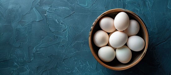 Poster - Directly above shot of white eggs in bowl on table with ample copy space for a fresh and healthy raw organic protein image