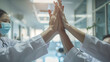 © VK Studio - Medical professionals high-fiving in a bright, modern hospital hallway, demonstrating teamwork, success, and a strong sense of community.
