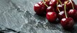 © Gular - Close up view of fresh cherries on a stone plate with selective focus creating a visually appealing copy space image