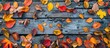 © Gular - Flat lay view of a fall themed backdrop with an assortment of vibrant autumn leaves on weathered wooden planks ideal for adding text in the copy space image