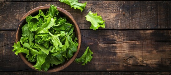 Poster - Top down view of a fresh green lettuce salad on a rustic wooden table Ideal for text placement Healthy dietary option with copy space image