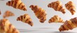 © meristock - French pastry croissants floating in the air on a white background in a captivating copy space image