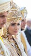 © Denisa - A bride adorned in detailed traditional attire stands beside two groomsmen, all participating in a wedding ceremony