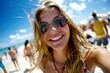 © ChaoticMind - A woman with blond hair and sunglasses smiles on the beach under a clear blue sky, exuding a relaxed and joyful summer vibe, surrounded by beachgoers and sunshine.