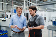 © Westend61 - Senior manager using tablet PC and explaining colleague at factory